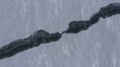 Aerial drone top down shot of a frozen lake with a crack through the middle  Stock Footage 146294426