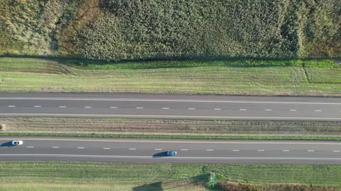 Aerial drone top down shot over vehicle movement along two way main road Stock Footage 220561864