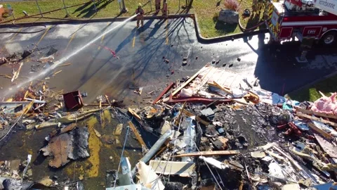 Aerial drone top down shot over firefighter shooting water through pipes Stock Footage 263800768