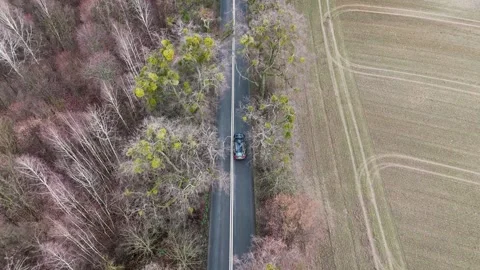 Aerial Drone Top Down Shot of Fast Black Car on Forest Road 스톡 동영상 323874937