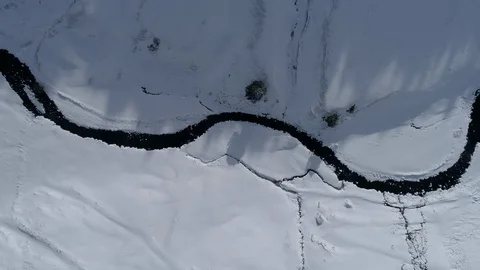 AERIAL DRONE TOP DOWN SIDE SHOT FOLLOWING FROZEN RIVER CROSSING SNOWED FIELDS Stock Footage 130133598