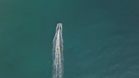 Aerial Drone Top Down View of Jet Ski riding inflatable banana boat in ocean Stock-Footage 128029226