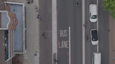 Aerial drone top down view over a road busy with lots of cyclists and cars Stock Footage 148671648