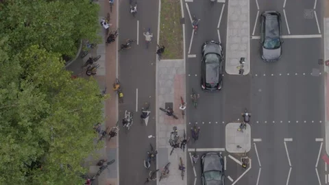 Aerial drone top down view over a road busy with lots of cyclists and cars Stock Footage 148672701