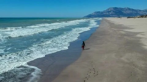 Aerial drone top down view of woman walking alone the beach. Patara Turkey 스톡 동영상 220288619