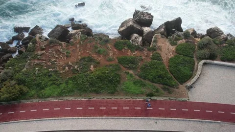 Aerial drone top down view of two unidentifiable people walking Stock Footage 220860404