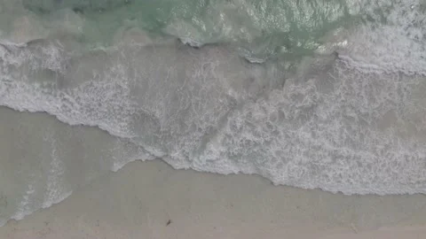 Aerial drone top down view of ocean blue waves and sand. Bird eye view to beach Stock Footage 233427585
