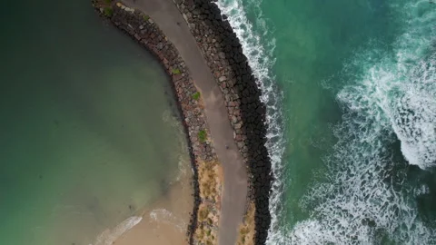 Aerial drone top down view tracking a tourist riding a bike on rock road Vidéo 248887085