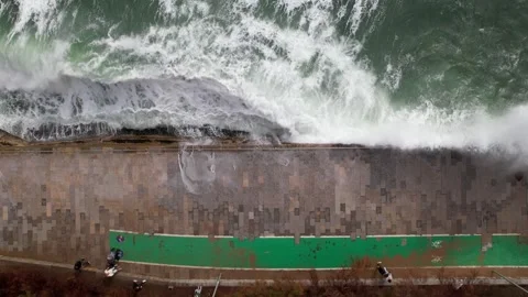 Aerial drone top down view of stormy waves hitting the promenade in Cascais Stock Footage 254335942