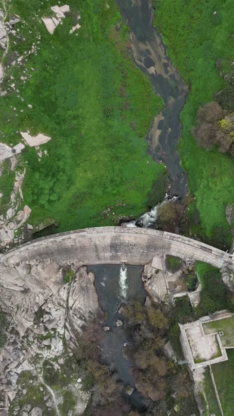 Aerial drone top down view a dam surrounded by lush greenery Stock Footage 293253568