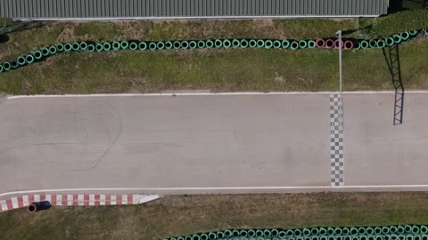 Aerial drone top down view of start and finish line of an empty go-karting track Stock Footage 298259686
