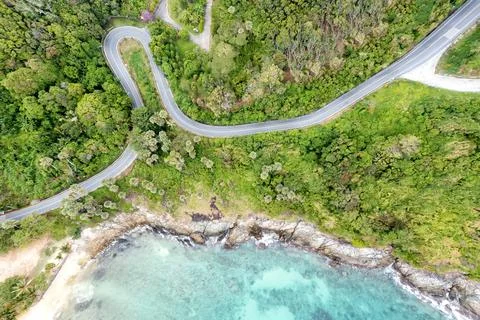 Aerial drone top down view of waves breaking in the sand with road and forest Stock Photos