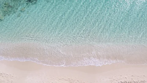 Aerial Drone Top-Down Zenithal still view of pink sand beach and turquoise water Stock Footage 130007728