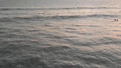 Aerial drone top view on ocean surf spot with waves and yellow red sunset with f Stock Footage 129553465