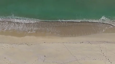 Aerial drone top view of sandy beach and green sea Stock Footage 324529565