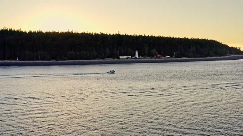 Aerial drone tracking boat heading out to sea, sunrise, vancouver island 库存影片 209350010