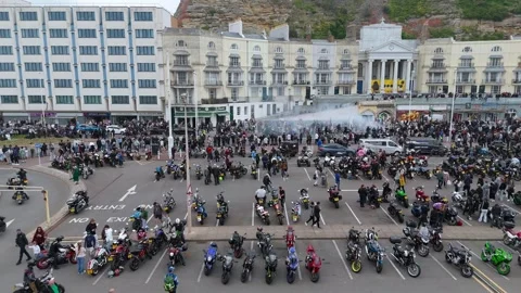 Aerial drone tracking left with motorcycle burnout smoke, May Day Bike Run, UK Stock Footage 335316433