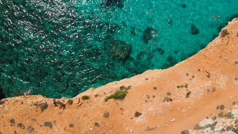 Aerial Drone tracking moving from cliffs revealing crowd of people swimming Stock Footage 111265957