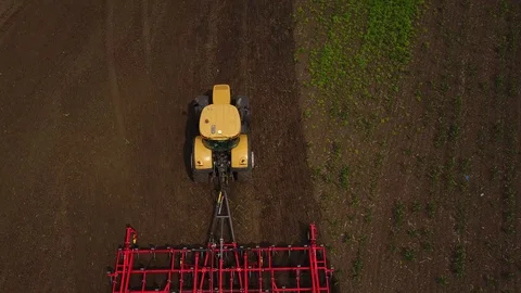 Aerial drone tracking shot of tractor seeding, sowing agricultural crops in a Stock Footage 87735699