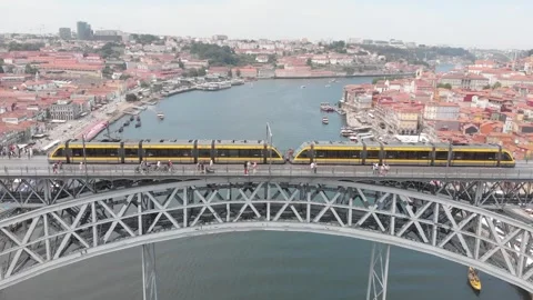 Aerial: Drone tracking tram moving across the upper deck of Dom Luis I Bridge 動画素材 345108943