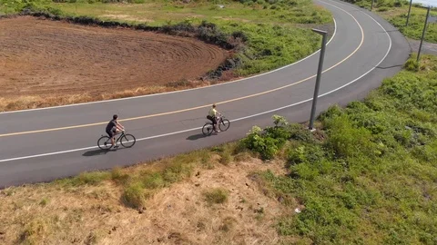 Aerial drone tracking two cyclists along coastal road Stock Footage 91092319