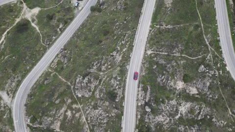 Aerial drone tracking view of a car along winding hairpin roads on the M-618 Stock Footage 293253652