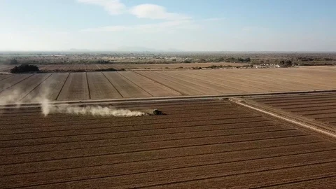 Aerial Drone of a Tractor Working in a Dusty Field - Dolly Forward, Look Down Stock Footage