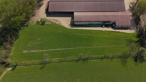 Aerial drone video capturing a modern equestrian center surrounded by the Stock Footage 341055081