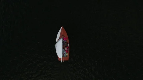 Aerial drone video directly down onto a small yacht on dark water Video stock 101978985