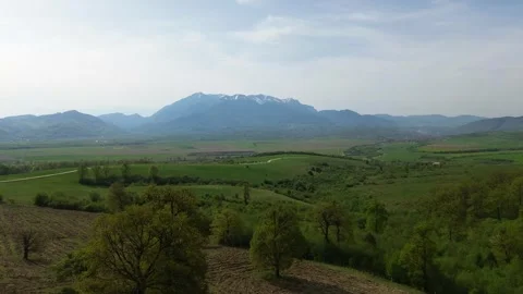 Aerial drone video of fields with a mountain in the background in Romania Stock Footage 273182504
