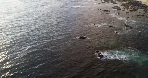 Aerial drone video flying parallel to the shore of a rocky coastline at sun.. Stock-Footage 288635052