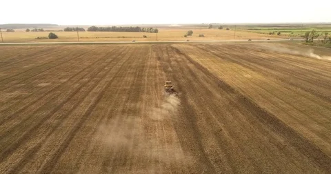 Aerial drone video of the harvesting machine in the field. The tractor plowing a Video stock 80736375