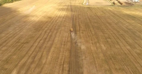 Aerial drone video of the harvesting machine in the field. The tractor plowing a Video stock 80747908