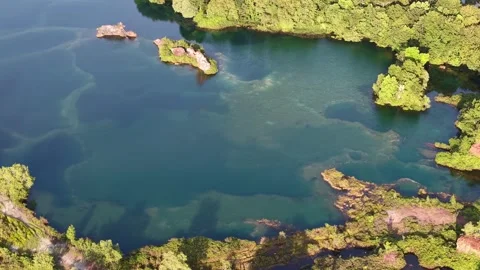 Aerial drone view of abandoned quarry lake with vegetated islets Stock-Footage 337724379