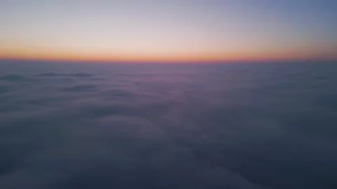 Aerial drone view above clouds at sunrise, high-altitude misty landscape with Stock Footage 300945163
