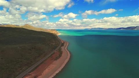 Aerial drone view along Bear Lake Utah shoreline with winding road Stock Footage 335080558