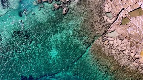 Aerial Drone View of Ancient Salt Pans and Turquoise Mediterranean Waters in Stock Footage 328386769