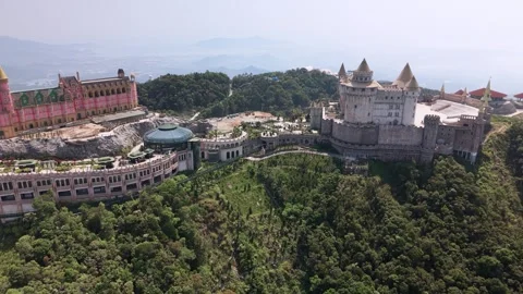 Aerial drone view of Ba Na Hills SunWorld complex surrounded by forest in Stock Footage 340029796