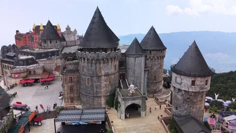 Aerial drone view of Ba Na Hills SunWorld castle complex surrounded by forested Stock Footage 340036780