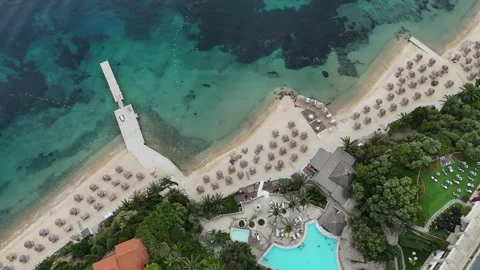 Aerial drone view of beach resort with umbrellas and pier in Halkidiki, Greece Stock Footage 327652352