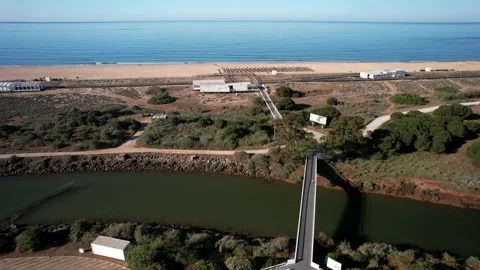 Aerial drone view of bridge crossing canal next to Praia de Falesia in Vilamoura Stock Footage 239462141
