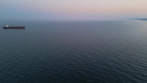 Aerial drone view of a bulk carrier cargo ship at sea during sunset. 스톡 동영상 331801822