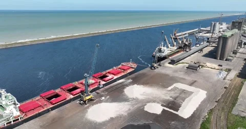 Aerial drone view of bulk transport of raw materials over the sea near a metal Stock Footage 256427042