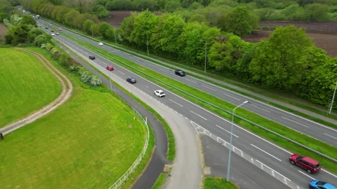 Aerial Drone View of Busy Multi‑Lane Highway with Cars and Green Landscape Stock Footage 333630939