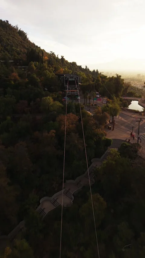 Aerial drone view of a cable car gondola moving over the green trees at Cer.. Stock Footage 339210545