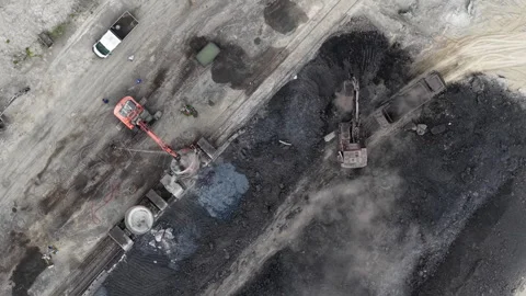 An aerial drone view captures excavators working in a large coal mine, loading Stock Footage 337470612