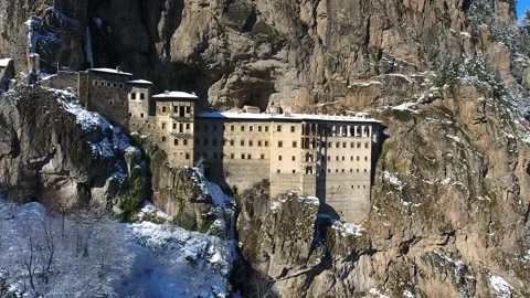 Aerial drone view captures snow covered Sumela Monastery clinging to steep Vídeos de archivo 333721768