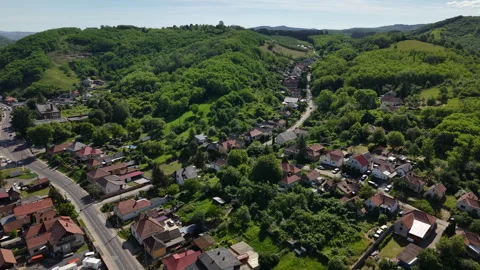 An aerial drone view captures a tranquil hungarian village nestled within lush Видео 336634925