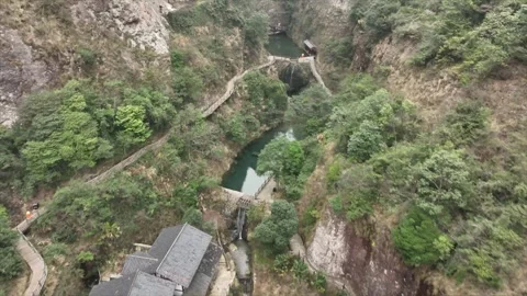 Aerial drone view capturing traditional buildings nestled amidst lush green Stock Footage 340106078