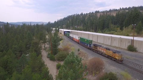 Aerial drone view, cargo freight shipping train on mountain forest railway Stock Footage 100861883
